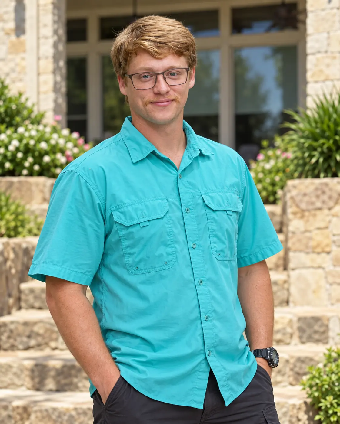The owner of Clean & Bright in a teal work shirt, standing in front of a stone house