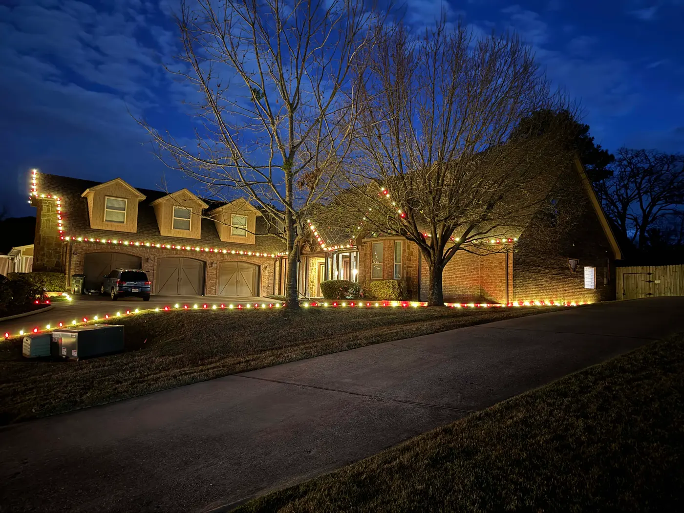 Holiday lights tracing a roofline and driveway