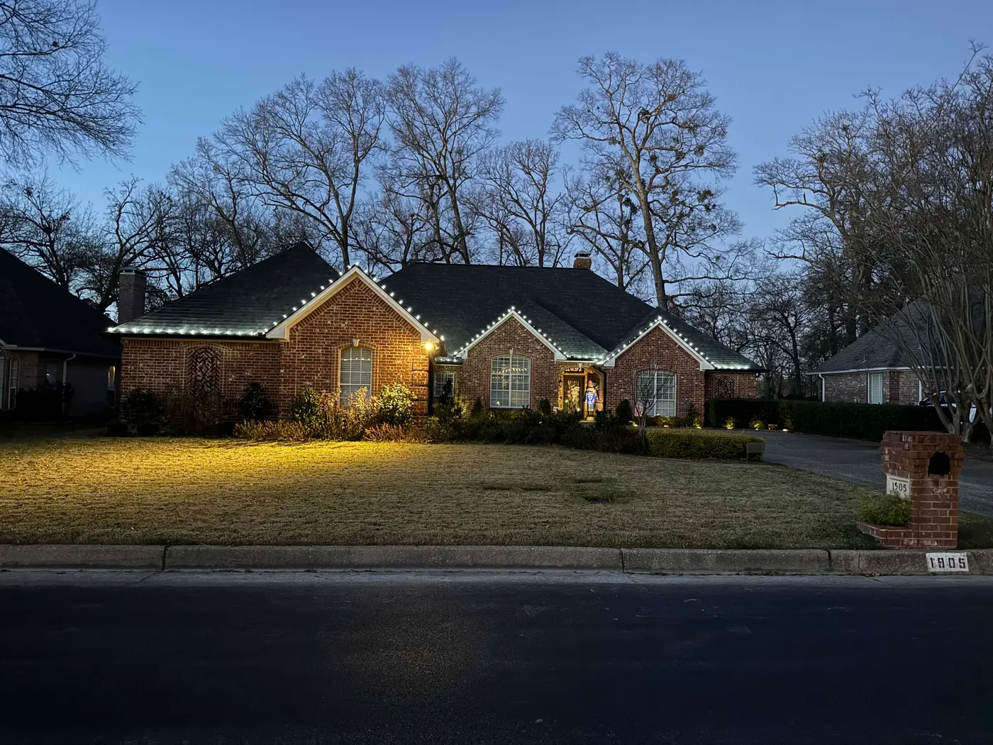 Brick home outlined in white holiday lights