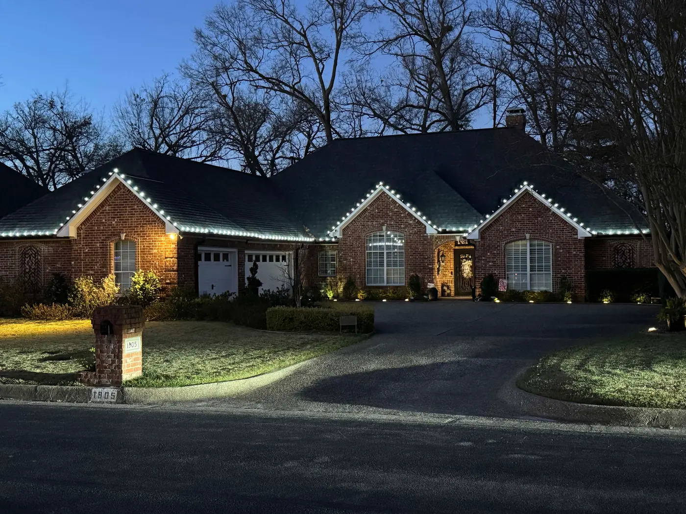 Closer view of white roofline lighting on a brick home