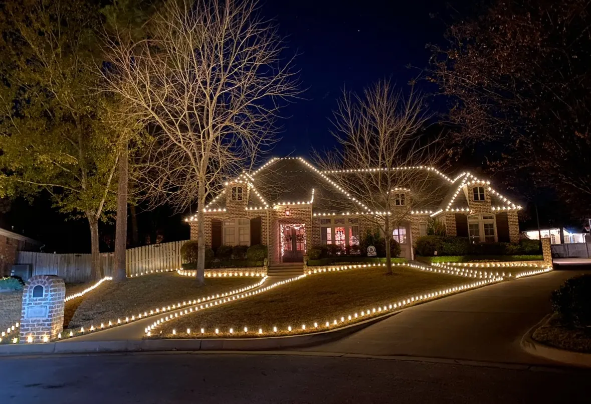 Brick home with warm white roofline and walkway lights