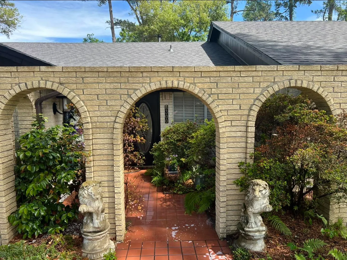 The same breezeway after washing, the brick back to pale tan above a bright terracotta walk