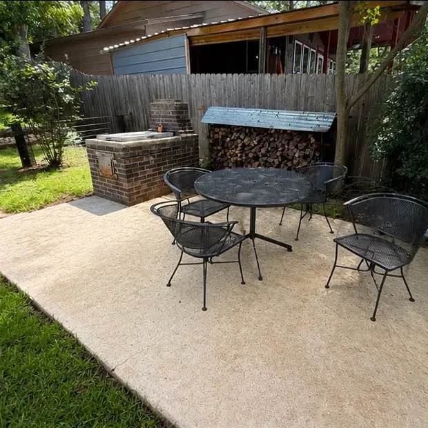 The same patio after washing, an even cream slab under the same table and chairs